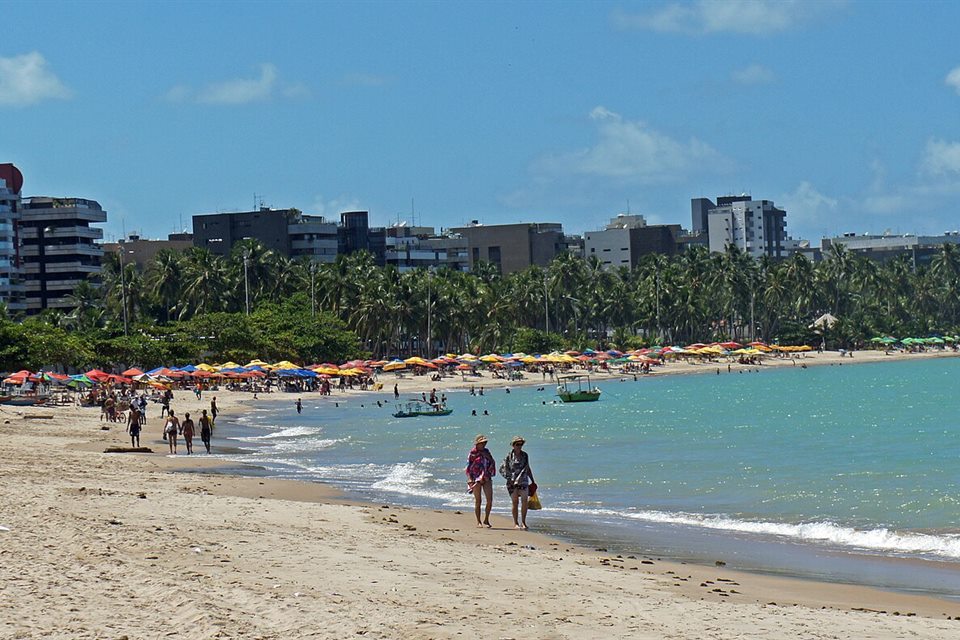 Praia da Pajuçara com coqueiros e prédios da orla