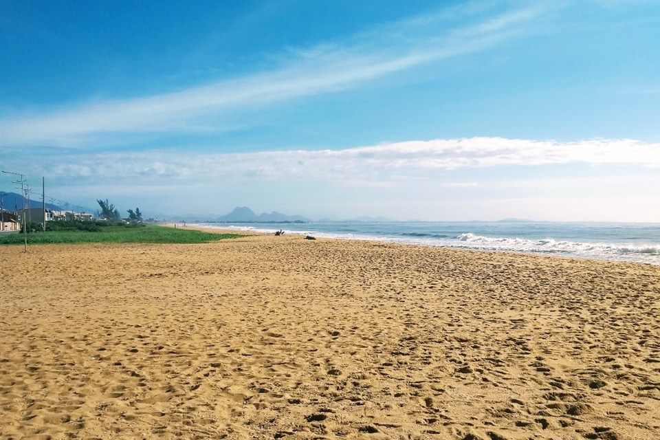 Areia dourada e mar azul na praia de Unamar